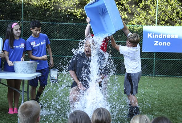 After a challenge by the middle school students at Our Lady of the Assumption Church in Atlanta, Archbishop Wilton D. Gregory showed his Chicago-style tolerance to cold as he takes one of four containers of ice and water over his head, while participating in the ice bucket challenge to benefit those with amyotrophic lateral sclerosis (ALS), Aug. 26. Photo By Michael Alexander