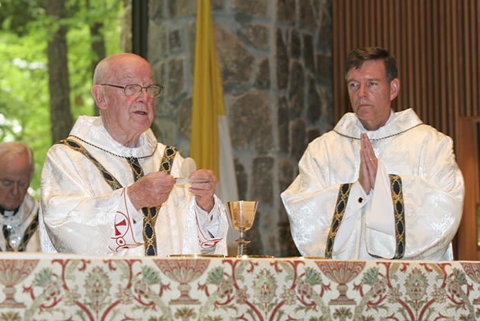 Deacon Bill Garrett, right, joins Msgr. R. Donald Kiernan at the altar during the Liturgy of the Eucharist when Msgr. Kiernan celebrated the 60th anniversary of his priesthood at All Saints Church, Dunwoody, in May of 2009. Photo By Michael Alexander