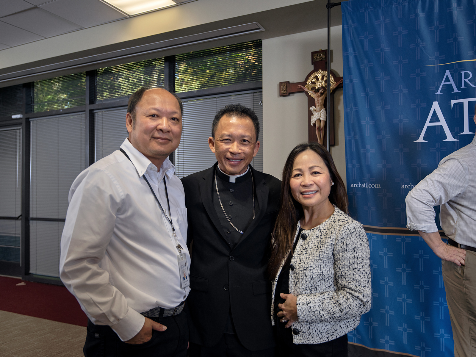 Bishop-designate John Nhan Tran, center, visits with Duke Nguyen, left, and Kim Vu, right. Vu and Nguyen serve as an advocate and notary for the Metropolitan Tribunal respectively and were on hand for the press conference announcing the new auxiliary's appointment Oct. 25 at the Chancery of the archdiocese.