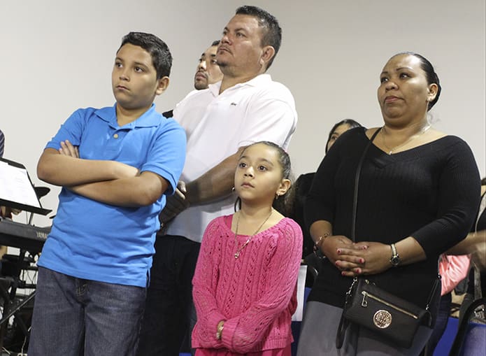 (Clockwise from top) Geovani Ramos, his wife Yesenia, his six-year-old daughter Gladys and his 10-year-old son Angel stand during the Liturgy of the Eucharist. Photo By Michael Alexander