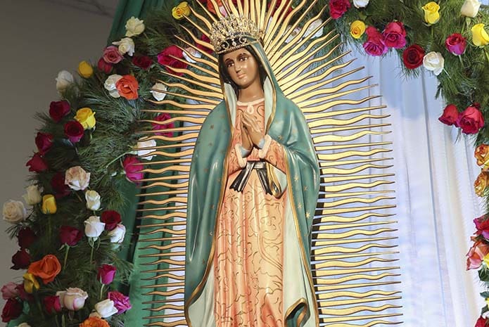 A statue of Our Lady of Guadalupe rests on a pedestal to the side of the main altar at San Felipe de Jesús Mission, Forest Park, several feet above the congregation, in view by all. Photo By Michael Alexander