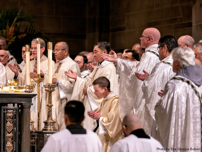 Priests pray together during the annual Chrism Mass held the Tuesday of Holy Week at the Cathedral of Christ the King. Photo by Johnathon Kelso