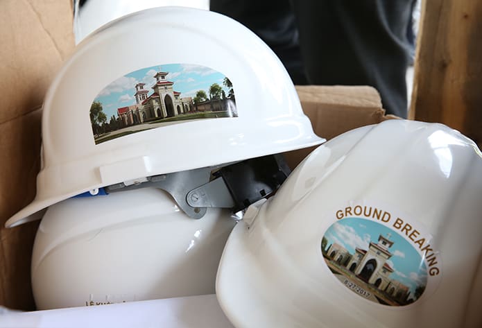 Special groundbreaking construction hats are stacked in a box until the ceremony takes place after the Aug. 27 Mass. Photo By Michael Alexander