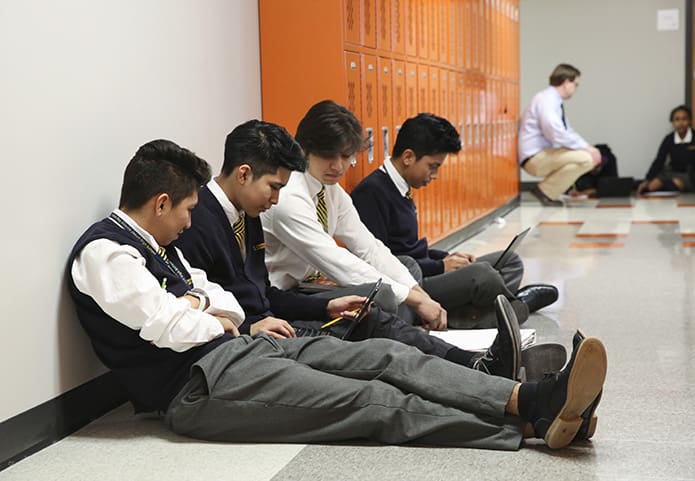 Sophomores (l-r) Jareth Vazquez, Edrasa Morales, Jean Ruisanchez and Joel Tomas work on a religion project as their instructor, Robert Rivers, background left, checks up on some other students. Photo By Michael Alexander