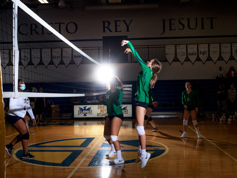 Notre Dame Academy's Ella Bianco (#4) hits near the net as Cristo Rey prepares to defend. Photo by Johnathon Kelso