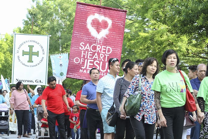 Sacred Heart of Jesus Church, Hartwell, and its banner processes in between two Norcross parishes. Holy Vietnamese Martyrs Church was ahead of them and St. Patrick Church was behind them. Photo By Michael Alexander