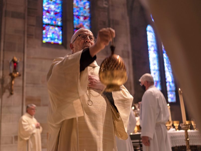 Deacon Jose Espinosa, co-director of diaconate formation for the archdiocese, censes Msgr. Frank McNamee during  the Mass. Photo by Johnathon Kelso