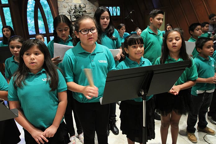 (Front row, left to right) Karen Mora, 9, Ariadna Hernandez, 10, Camila Dodinez, 8, Alejandra Rios, 8, and Rafael Nunez, 7, sing the opening hymn during the Sept. 22 evening Spanish Mass. Photo By Michael Alexander