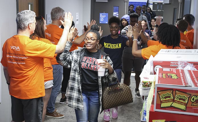 Employees from Voya Financial line the walls to greet seniors after completing the final exam of their senior year, AP Calculus. In the foreground are Asia Belt, who is attending Haverford College, Haverford, Pa., and Briyhan Martin, who is attending the University of Michigan, Ann Arbor, Mich. The employees also served as volunteers during the senior picnic that followed the test. Photo By Michael Alexander