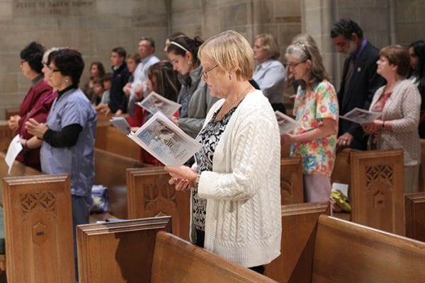 Linda Perri, foreground, of Prince of Peace Church, Flowery Branch, stands among others in attendance at the Oct. 17 White Mass, a liturgy honoring Catholic healthcare professionals. Perri's husband Robert is a physician and he served on the altar during the Mass with other deacons in formation. Photo By Michael Alexander