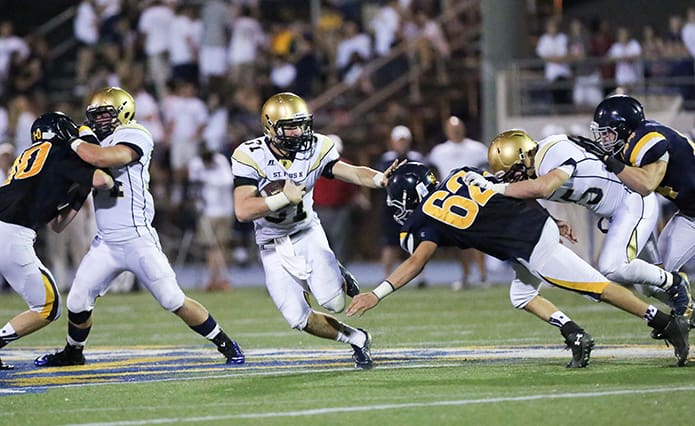 St. Pius running back Ransom Klinger (#31) stiff arms a Marist player as he runs through a hole created by the Pius offensive line. Photo By Rob Buechner