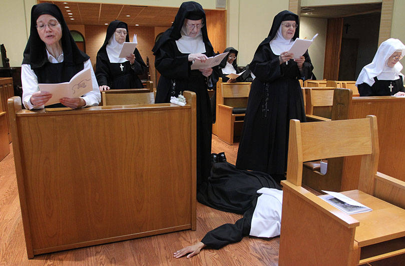 Sister Teresa Maria Kulangara prostrates herself before the Lord during the Litany of the Saints as the sisters and the congregation sing. Photo By Michael Alexander                