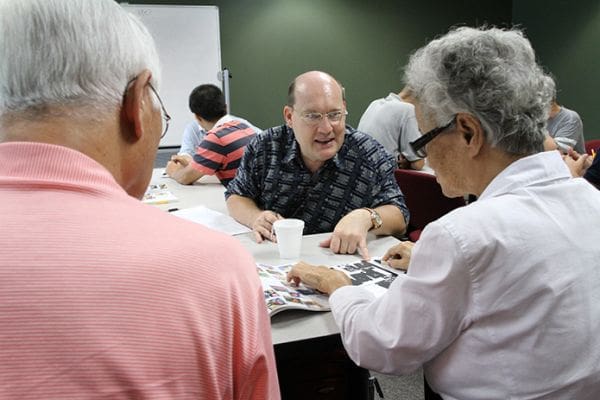 Boris Elatantsev, center, of Russia interviews Jung Bak, foreground right, of Korea in English about her favorite kind of movies. Seated next to Bak is her husband of 59 years Jeom. Elatantsev started the class in July and the Baks have been attending for two and half years. Photo By Michael Alexander