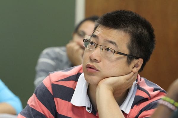 Hu Li of China looks toward the board as they go over English words related to automobile parts. Photo By Michael Alexander