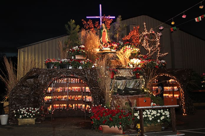 Under the night sky a floodlight, stringed lights and candles illuminate the shrine honoring Our Lady of Guadalupe at Our Lady of the Americas Mission, Lilburn. Photo By Michael Alexander