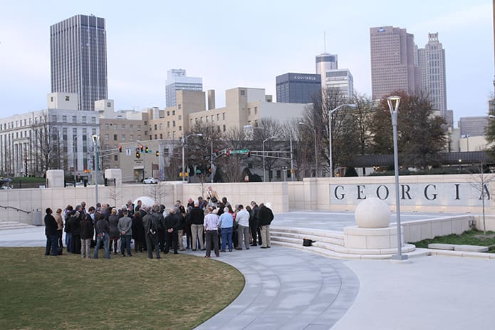 Lay people and clerics pray for an end to the death penalty at Liberty Plaza with the downtown Atlanta skyline as a backdrop. Photo By Michael Alexander