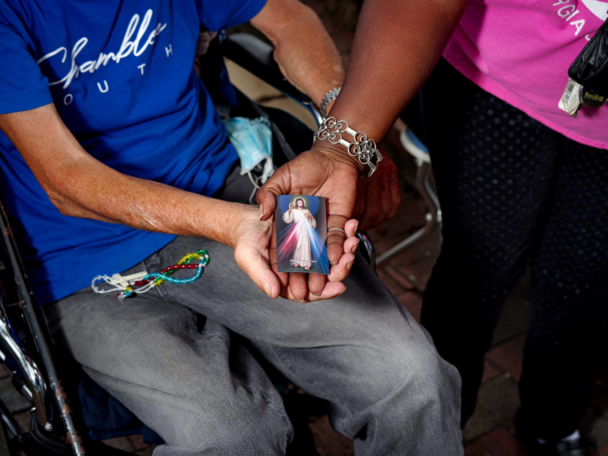 Kenneth and Valarie Richards hold a prayer card given to them by Legion of Mary members during a day of street evangelization in Little Five Points. Photo by Johnathon Kelso