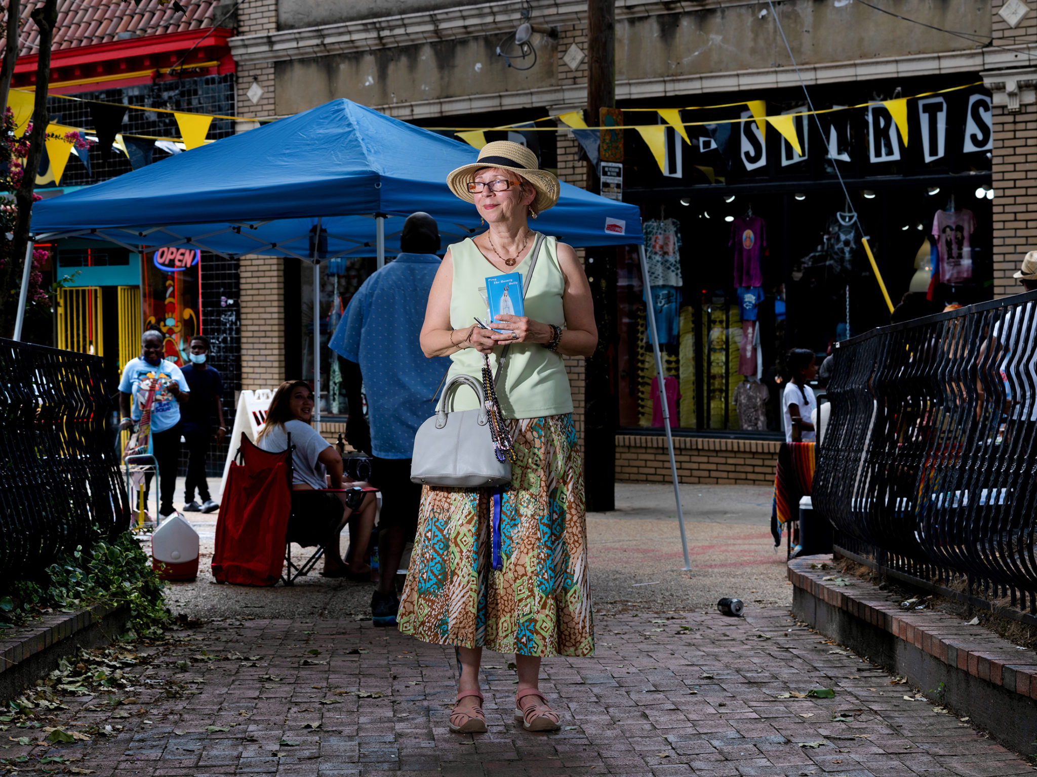 Legion of Mary member Marjorie Diaz hands out rosaries and prayer cards in Little Five Points during a day of street evangelization. The legion is celebrating 100 years of ministry. Photo by Johnathon Kelso