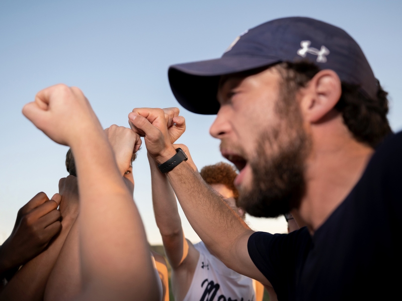 Marist Cross-Country Coach Matt McMurray and the Junior Varsity Championship boys get excited before their first race of the evening at the Wingfoot XC Classic. Photo by Johnathon Kelso