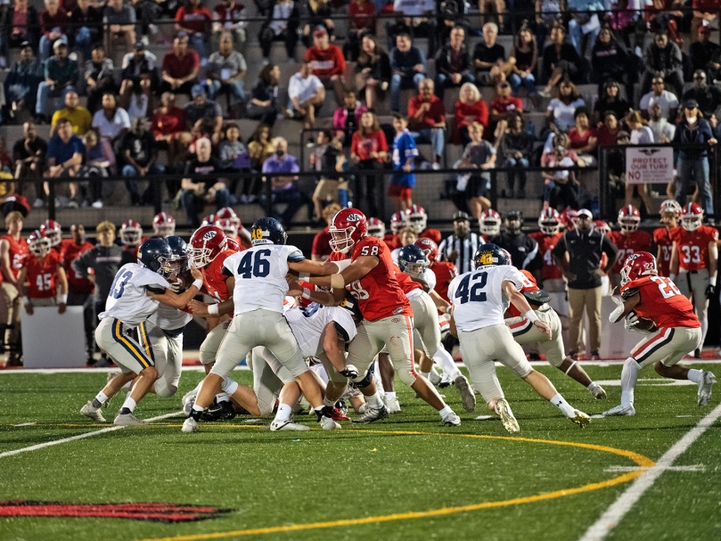 Woodward Academy running back Lucas Farrington, pictured far right, attempts to break through the Marist War Eagle defensive line during the second quarter. Photo by Johnathon Kelso