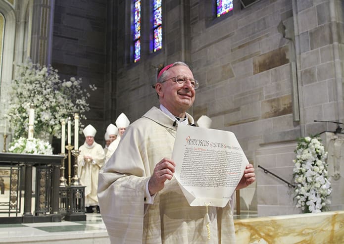 After the apostolic letter was read by Archbishop Christophe Pierre, the apostolic nuncio to the United States, and presented to Archbishop Wilton D. Gregory, Bishop-designate Joel M. Konzen, SM, walked with it off the altar and down the center aisle to a round of applause throughout the church. The April 3 episcopal ordination took place at the Cathedral of Christ the King, Atlanta. Photo By Michael Alexander