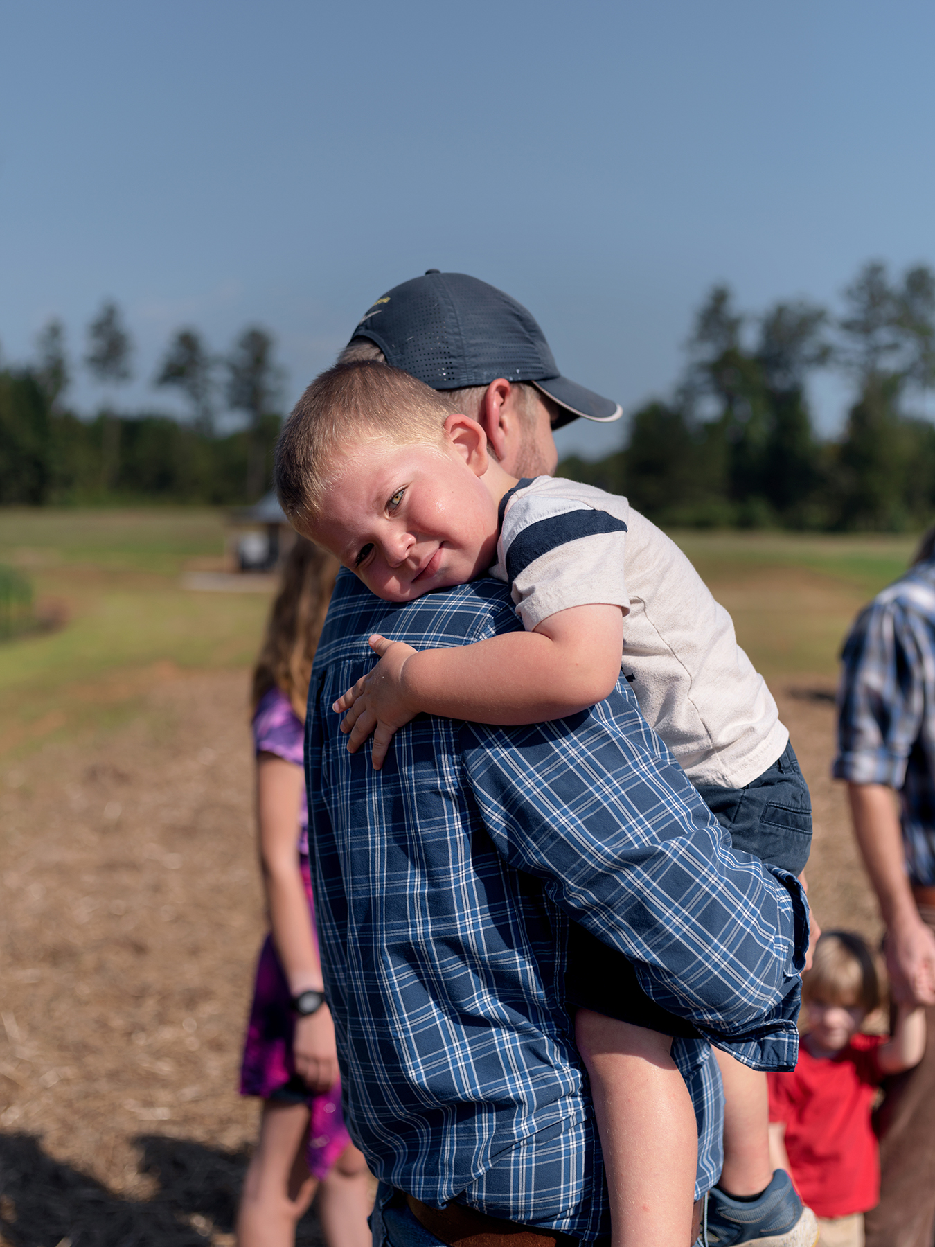 Jeff Lansford holds his son during the dedication of the Seven Sorrows Walk at Heritage Preserve Sept. 11. Photo by Johnathon Kelso