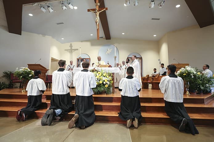 As altar servers kneel at the foot of the altar, Archbishop Wilton D. Gregory is joined around the altar by his brother clergy during the Liturgy of the Eucharist. They were all present for the June 24 Mass of blessing and dedication for the new St. Bernadette Parish Center, Cedartown. Photo By Michael Alexander