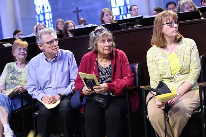 Sitting in chairs along the center aisle, between the prayer stalls, (l-r) Betty Canfield of St. Lawrence Church, Lawrenceville, and John and Anna Gallagher and Susan Parrott of St. James Church in Madison listen to Archbishop Wilton D. Gregory’s homily at the Monastery of the Holy Spirit, Conyers. Photo by Michael Alexander