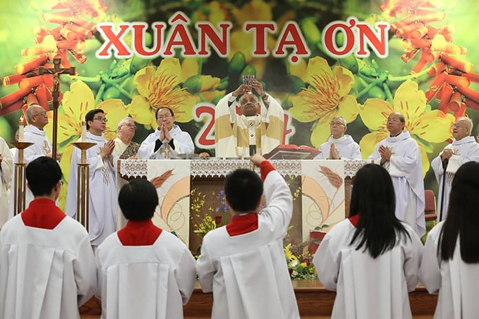 Surrounded by clergy and altar servers, Archbishop Wilton D. Gregory elevates the chalice during the Mass of Dedication at Our Lady of Vietnam Church, Riverdale, Feb. 2. Photo By Michael Alexander