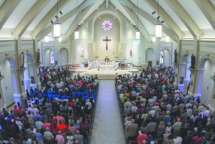 Clergy, including visiting priests and former pastors, join Archbishop Wilton D. Gregory around the altar. The new church has a seating capacity of 1,100. Photo By Michael Alexander