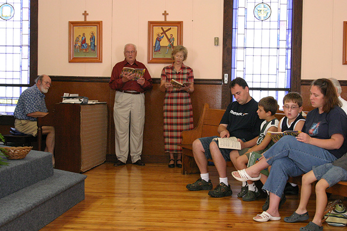 (L-r) Rick Hansard, on piano, is joined by Herb Leinberger and Susan Walker as they sing the offertory hymn 