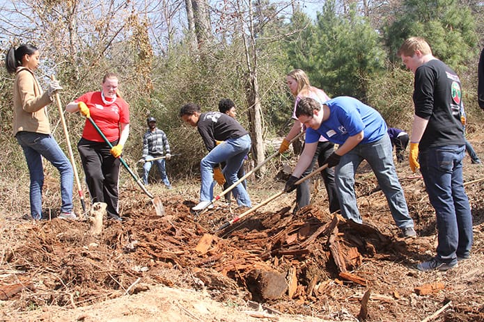 University of Georgia students participate in a March beautification project on the grounds of Oasis CatÃ³lico Santa Rafaela, inside the Pinewood Estates North mobile home community, Athens. Some of the students are members of Project Hope, a student organization that works to help the trailer community. Photo By Michael Alexander