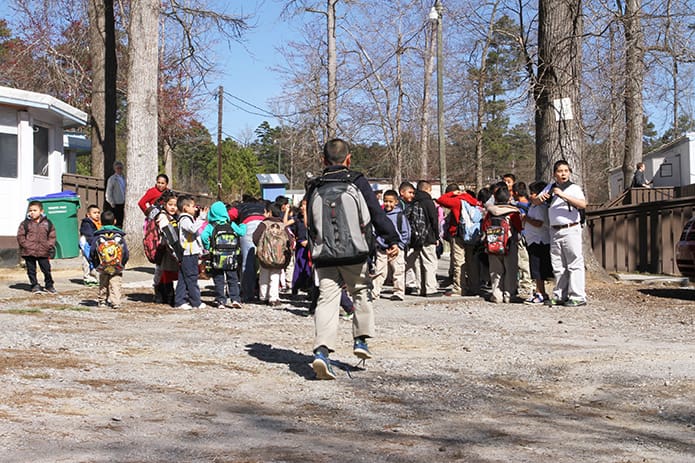 A child runs from the school bus to join others at Oasis CatÃ³lico Santa Rafaela, Athens, for the after-school program, which is offered Monday through Thursday by the Handmaids of the Sacred Heart of Jesus sisters. The program serves 105 children tutored by students from the University of Georgia. Photo By Michael Alexander