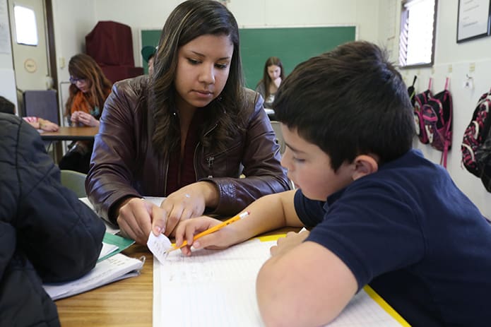 Courtney Smith, a junior health promotions major from Stockbridge, tutors seven-year-old Johnny Reyna in the second grade trailer. Photo By Michael Alexander