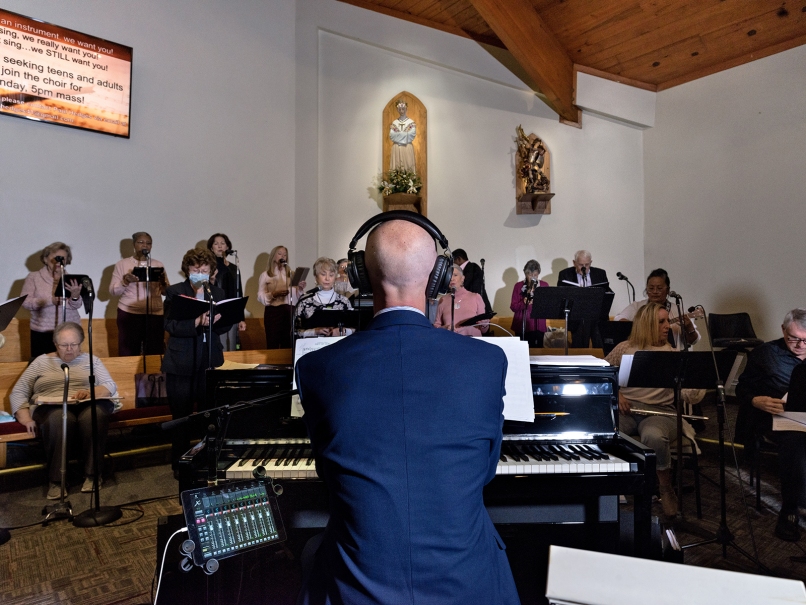 Lucas McHenry, Director of Music and Liturgy at at St. Oliver Plunkett Church, leads the choir during a Mass in honor of Our Lady of Guadalupe. Photo by Johnathon Kelso