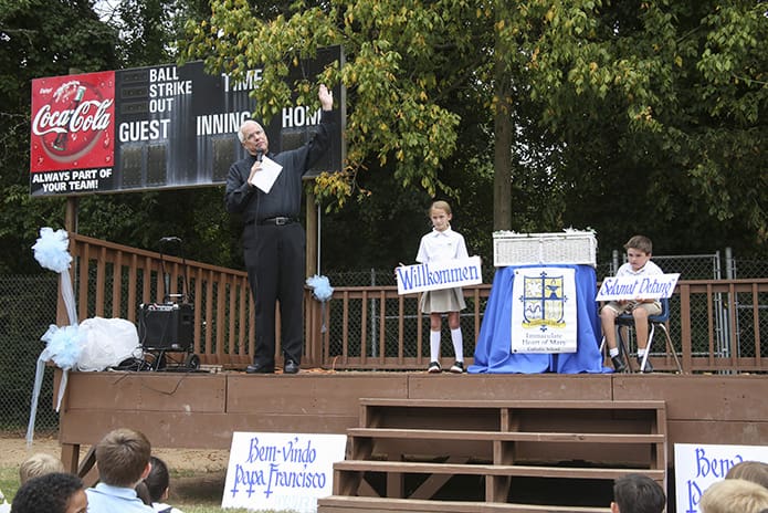 Pointing skyward, Msgr. Albert Jowdy, standing left, pastor of Immaculate Heart of Mary Church, Atlanta, informs the students that any one of the planes flying overhead could be Pope Francis on his way to Washington, D.C. from Cuba. Photo By Michael Alexander