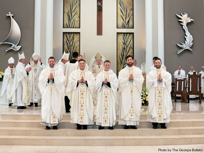 The newly ordained priests pose for a photo following the Mass at Holy Vietnamese Martyrs Church June 1. From left to right, are David DesPres, Joseph Nguyen, Colin Patrick, Mr. Arturo Merriman, and Jared Kleinwaechter. Photo by Johnathon Kelso