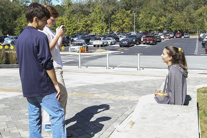 Marist School sophomores Lucas Cantuaria, Harrison Ford and Isabella Hay film a public service announcement on their smartphone to help boost awareness about the issue of human trafficking. It was one aspect of the school’s Oct. 13 Informed Discourse Day, a day for dialogue, discussion and debate exploring human trafficking. Photo By Michael Alexander
