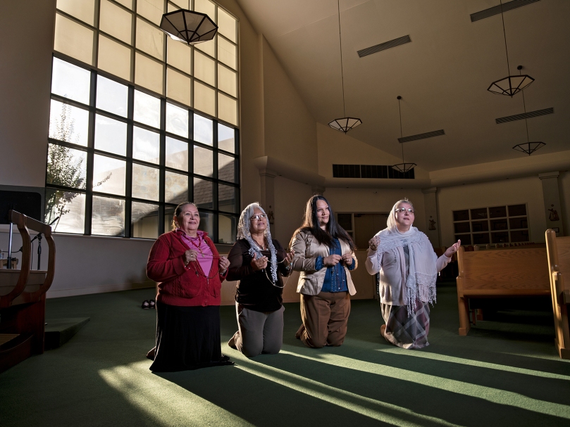 Members of the Seven Sisters Apostolate pray for their parochial vicar, Father Javier Muñoz, in the sanctuary at St. Pius X Church in Conyers. From left to right are María De La Luz Silva, Fermina Consla, Hilda Pelayo, and Olga Jennings. Photo by Johnathon Kelso