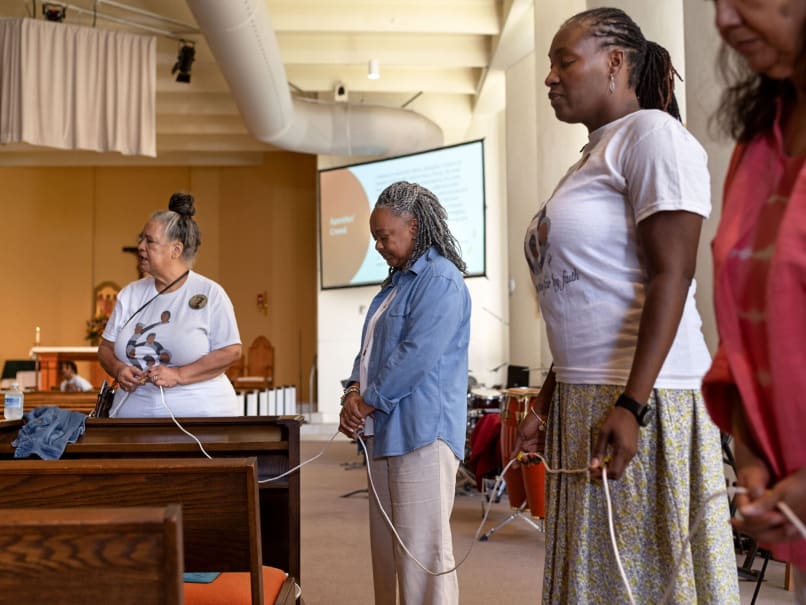 Judy Sheppard, center, from Christ Our Hope church in Lithonia, prays a living rosary with Sts. Peter and Paul parishioners Barbara Graham, left, and Alberta Therlonge, right. The rosary was part of an effort to highlight the canonization cause of the Saintly Six. Photo by Johnathon Kelso