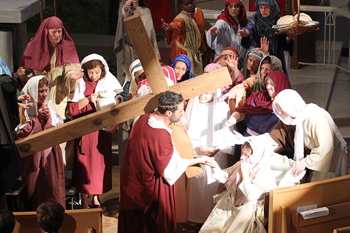 After falling a second time, Jesus (Anthony Mari) resumes his walk pass the women and children of Jerusalem to Golgotha, the site of his crucifixion.