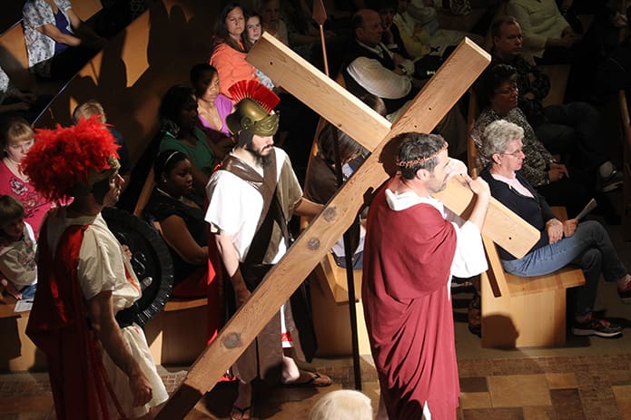 Followed by soldiers, Jesus carries the cross as he walks on the road to Calvary.