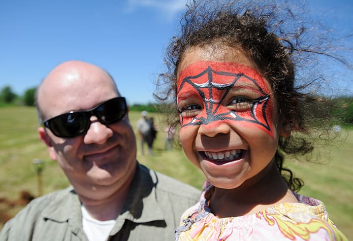 Here she proudly shows off the completed work of the face painting artist. Photo By Gibbs Frazeur