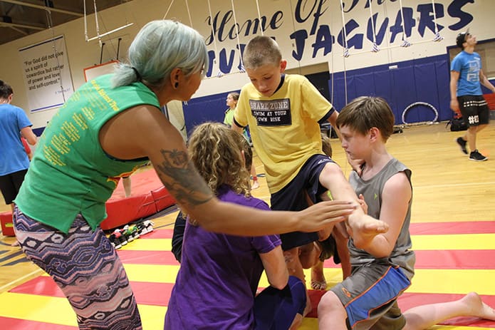 (L-r) Human balancing act instructors Alyssa Luna and Alex Quinn help Evan Hoekstra lift himself upward as he gets help from fellow sixth-grader Brendan Wild, far right. Photo By Michael Alexander