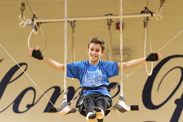 With every repetition of the swinging trapeze act, Evan Sitzmann gained confidence. Photo By Michael Alexander