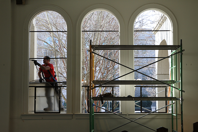 Foothill Sand To Glass employee David Mitchell removes the T-bars from the window frames after all the stained glass window panels have been removed, so the windows can be recovered with Lexan polycarbonate sheets. Photo By Michael Alexander