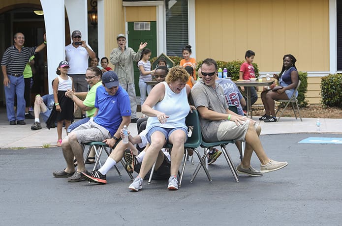 The cake walk was one of the most competitive games conducted that day. (Counter-clockwise, third from left) Deacon Frank Przybylek (on ground) is unable to beat Christine Butler, the eventual overall winner, to a chair as the music stops. Zach Schlag, Scott Evans, David Metellus, Frances Rentas and Father Ignacio Morales, pastor of St. John Vianney Church, Lithia Springs, were the other participants. Photo By Michael Alexander