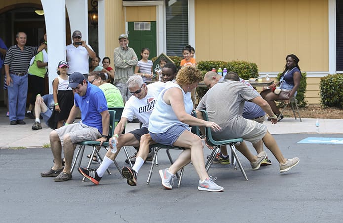 The cake walk was one of the most competitive games conducted during that day. (Counter-clockwise, from left) Father Ignacio Morales, pastor of St. John Vianney Church, Lithia Springs, the Deacon Frank Przybylek , Christine Butler, Zach Schlag, Scott Evans, David Metellus and Frances Rentas try to secure a chair as the music comes to a stop. Photo By Michael Alexander