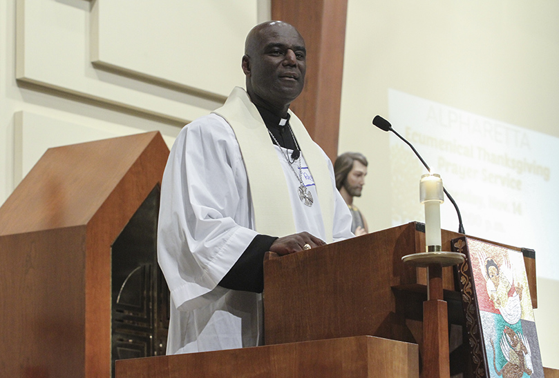 Father Reginald Simmons of St. Aidan’s Episcopal Church, Alpharetta, delivers a sermon on the theme of “God Will Provide.” His church, along with five other local faith communities, gathered at St. Thomas Aquinas Church for the ninth annual Alpharetta Community Thanksgiving Service. Photo By Michael Alexander