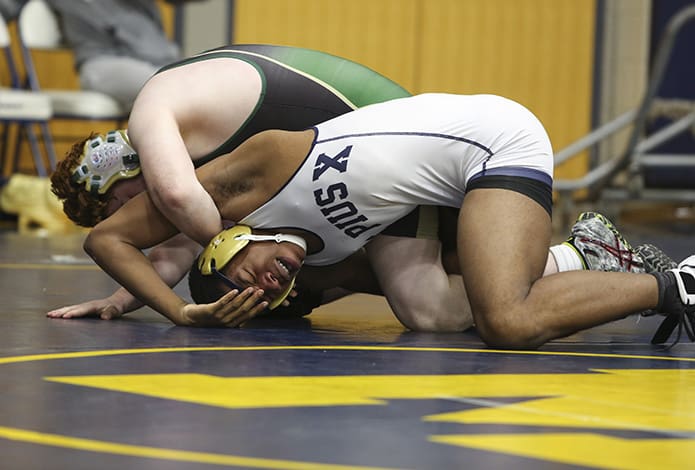 Heads, arms and elbows converge as Blessed Trinity's John Jacobs, top, wrestles to an overtime win against St. Pius X's Kellen Haynes in the 2016 Catholic Duals. Photo By Michael Alexander